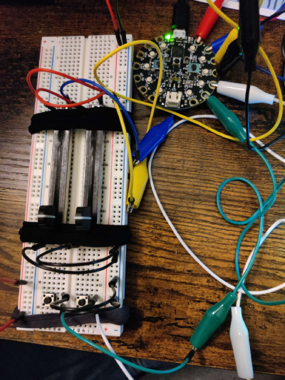 Prototype of the Lever Up! Jam controller on a breadboard. Two sliding variable resistors and two buttons connected to the Adafruit Playground board.